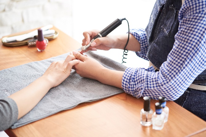 爪にマニキュアを塗っている